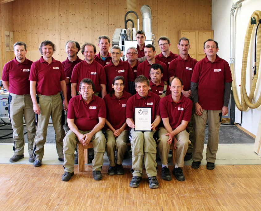 Gruppenfoto Mitarbeiterinnen und Mitarbeiter der IWL halten die Urkunden von der pure position Auszeichnung german design award