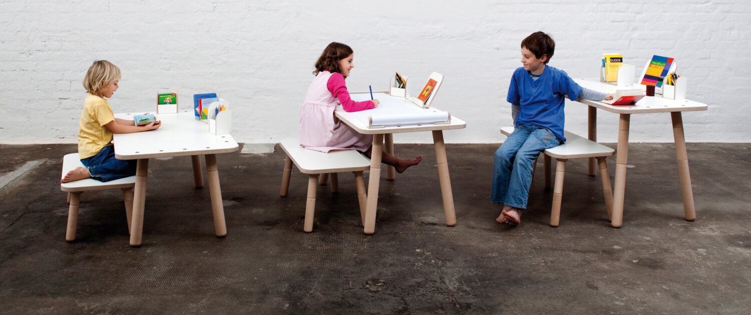 Drei verschiedene Beispiele der Höhenverstellung beim growing table mit Kindern an den Schreibtischen