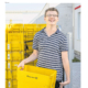 Titelbild vom Magazin FR7 mit einem glücklichen Menschen mit Behinderung der eine gelbe Wanne von der Deutschen Post hält und im Hintergrund mehrere Wannen stehen